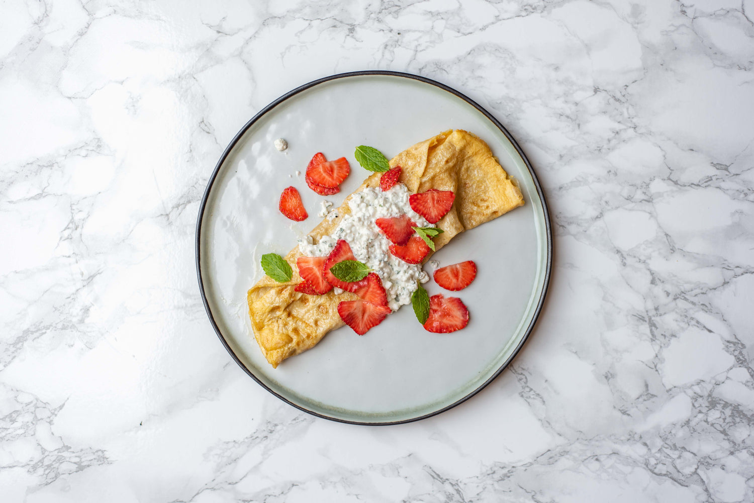 Ontbijtwrap (omelet) met hüttenkäse en verse aardbeien