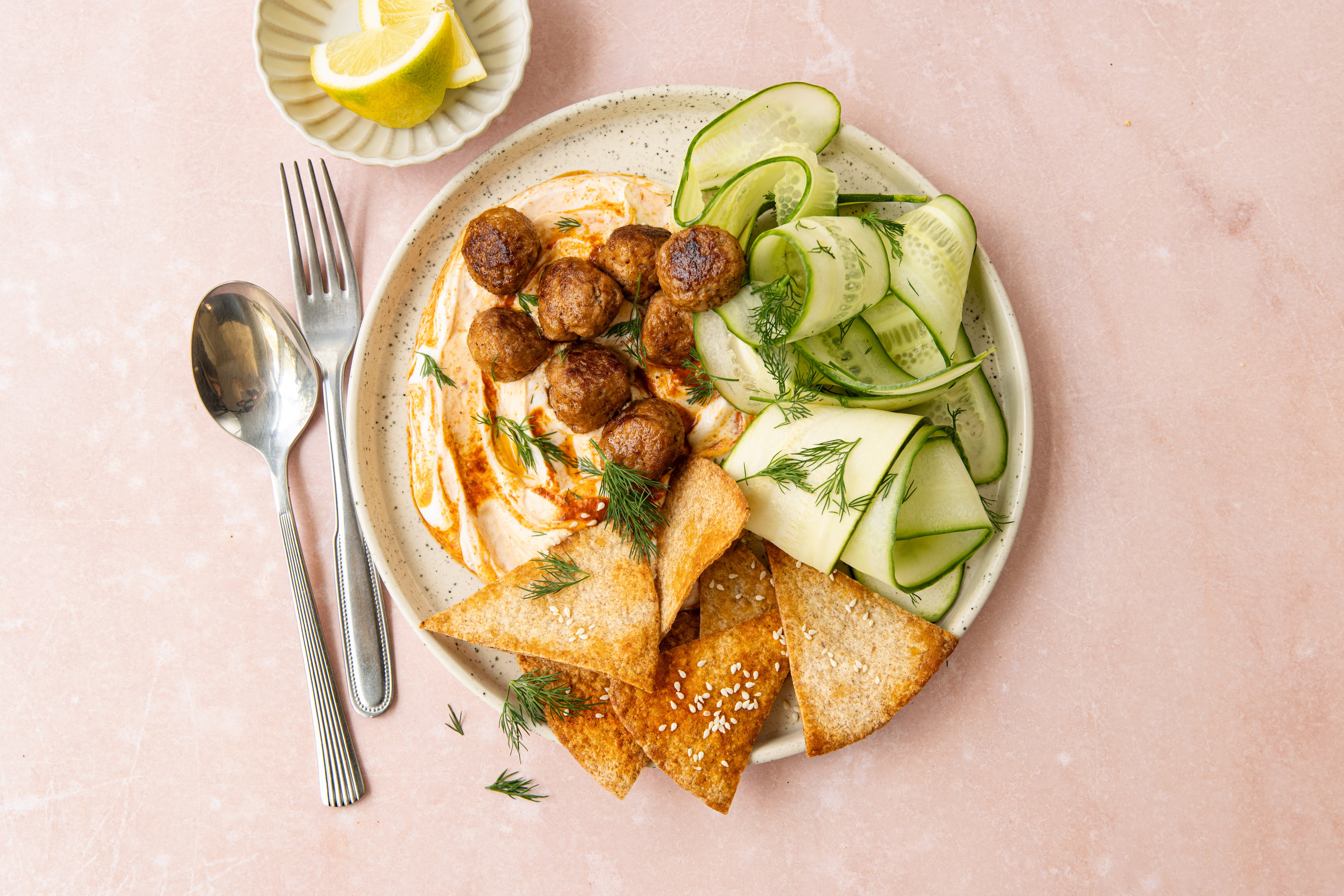Kipgehaktballetjes met yoghurt-harissa, komkommersalade & krokante wrapdriehoekjes