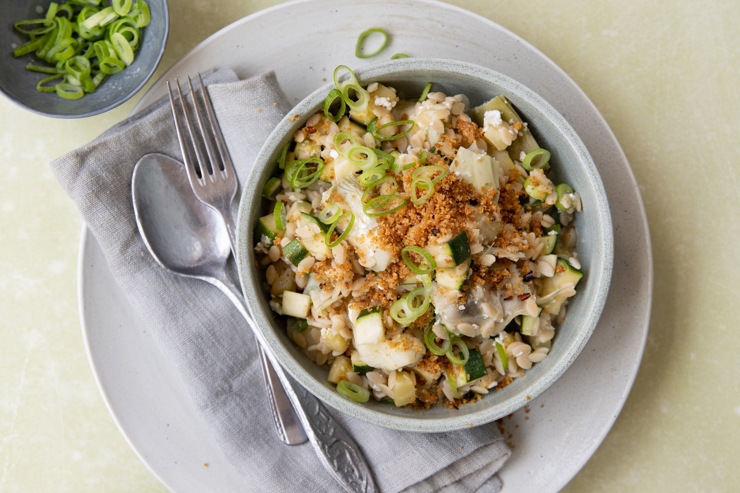 Orzo met courgette, groene asperges, artisjok en citroen-parmezaancrunch