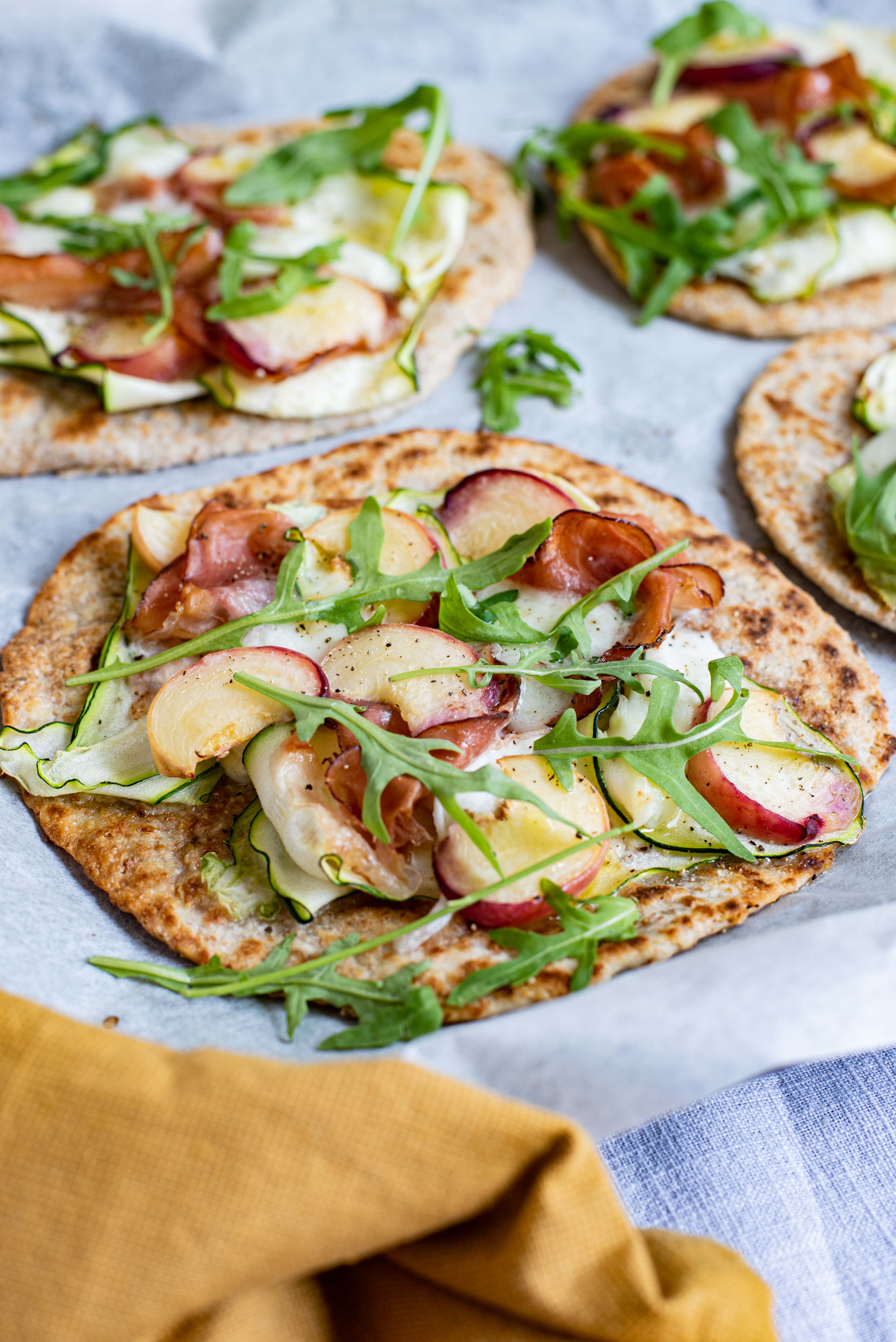 Flatbread met rauwe ham, mozzarella, perzik en courgette